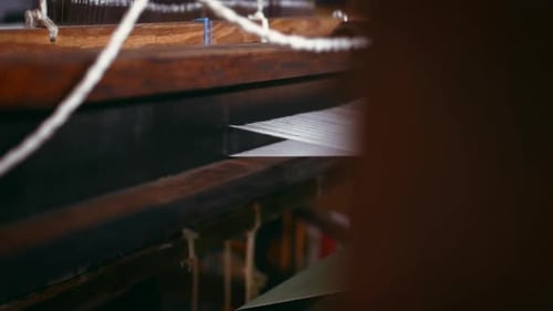 Loom, weave and hands of man with textile, fabric and material for production in workshop