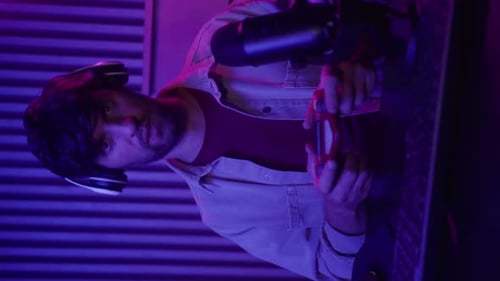 Man with Game Controller Smiles in Purple Light