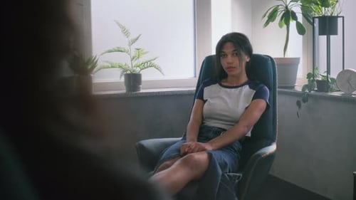 Young Woman Sitting in Armchair, Talking to Therapist