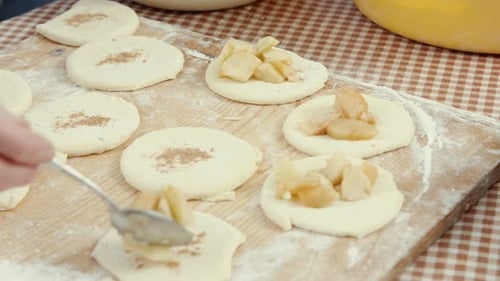 Cooking and Home Concept Close Up of Female Hands Putting Apple Jam on the Dough Circles for Baking