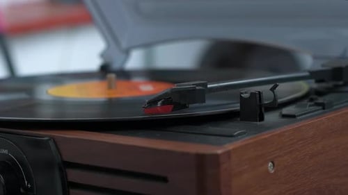Hand Placing Needle on Spinning Record Player