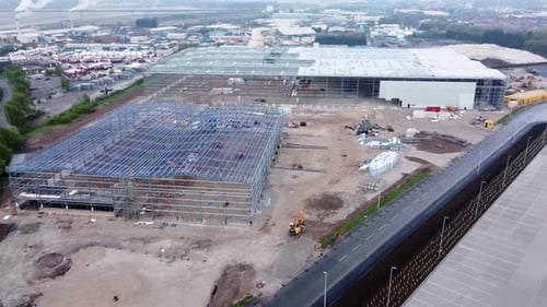 Sitio de construcción de edificio industrial moderno sin terminar, ensamblaje de estructura de acero, vista aérea, panorámica