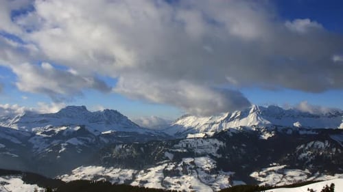 Time-lapse of a winter mountain scene in the French Alps, showing clouds moving over mountain peaks