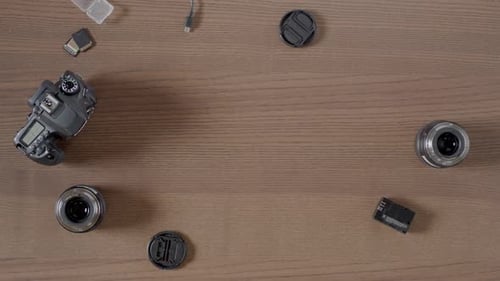Camera and Equipment Laid out on a Wooden Table