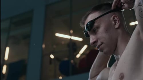 Male Athlete Putting on Swimming Goggles before Race