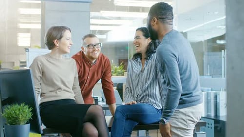 Diverse Group of Four Talented Young Professionals Having Team Building Conversation, Joking and Ha