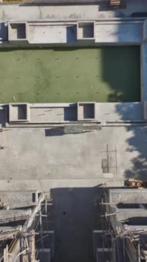 Vídeo vertical: Fabricación de metales, trabajos de fachada y corte de piedra en curso en una construcción ajetreada
