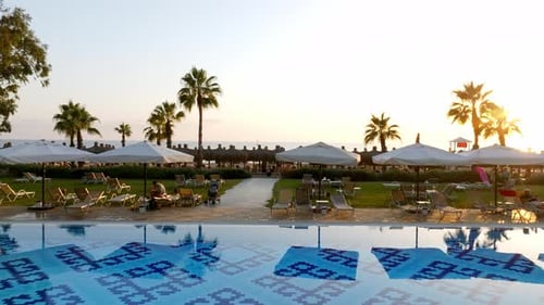 Luxurious Beach Resort with Swimming Pool and Beach Chairs and Palm Trees