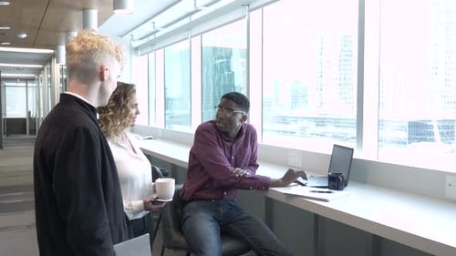 Business people meeting in coworking space office window discussing plans together