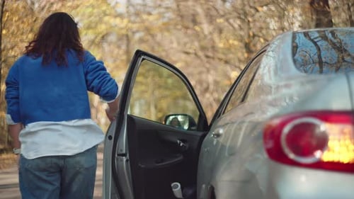 Woman Exiting Car on Autumn Road