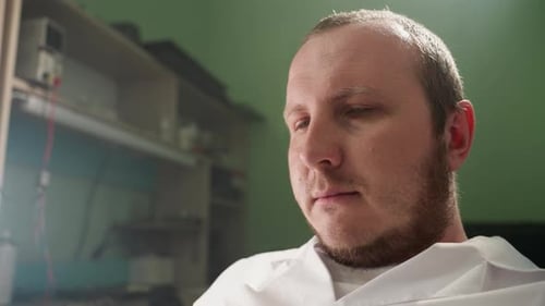 Man in White Coat Looking Attentively