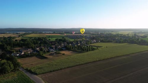 Hot Air Balloons Floating Above Rural Landscape