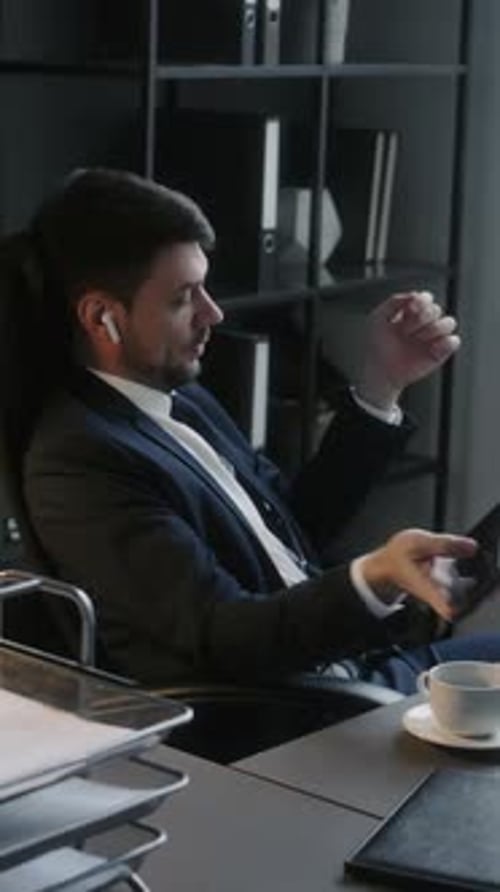 Man in Suit Using Smartphone in Office
