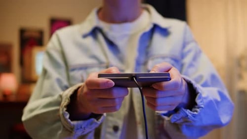 Person Using Retro Game Controller with Phone