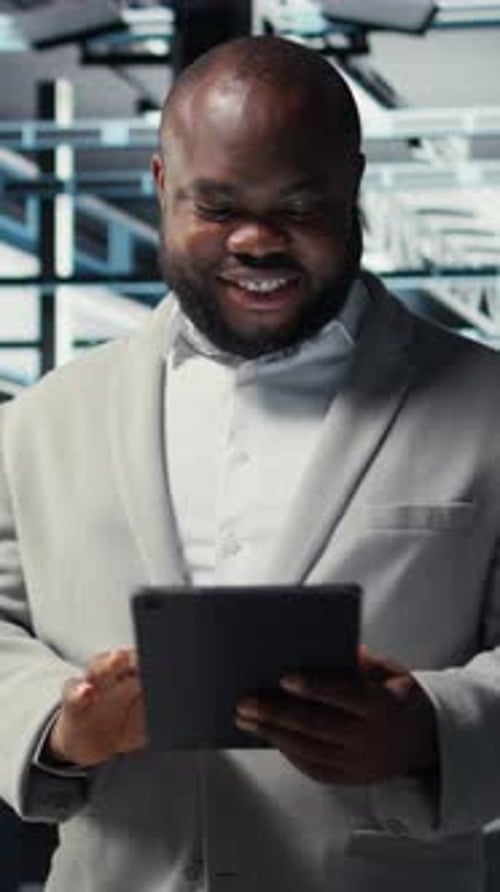 Vertical Video Close Up of Technician Walking in Data Center Using Tablet to Check Equipment