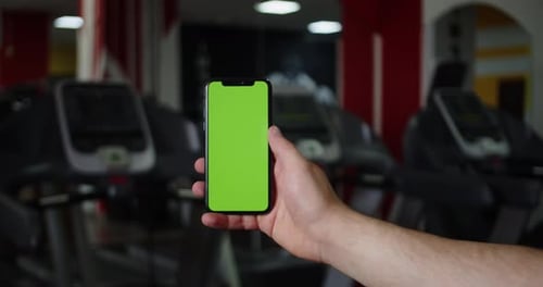 Back View of Fitness Woman Using Green Screen Smart Phone at Home