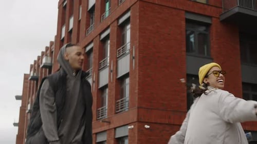 Romantic Biracial Couple Running Together along Street and Laughing