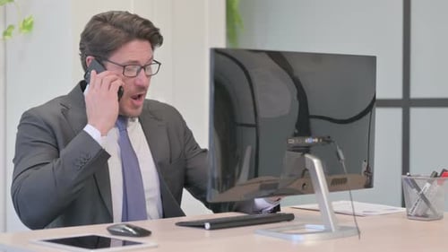 Businessman Talking on Phone in Office Setting