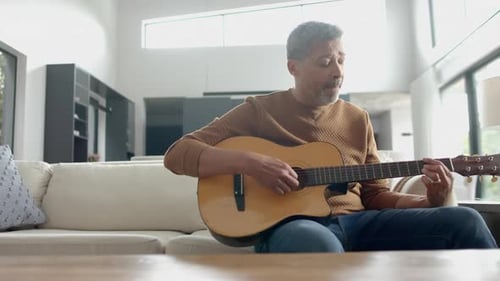 Man Plays Guitar and Sings on Couch