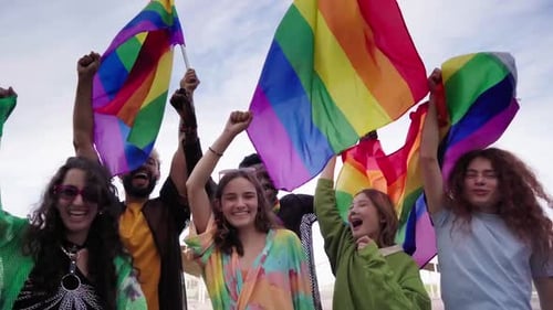 Group Waving Pride Flags in an Urban Setting