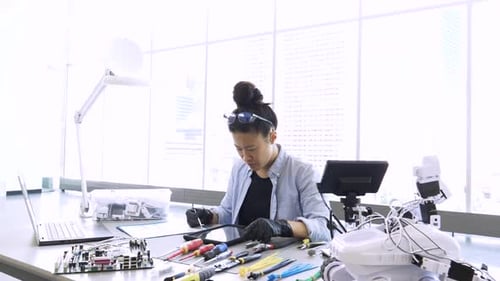 Ingeniera con tableta digital que trabaja en un laboratorio de robótica para adultos