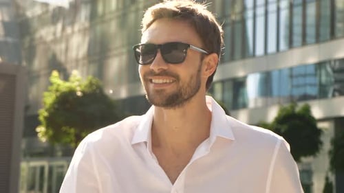 Smiling Man Walking Outdoors in Urban Setting