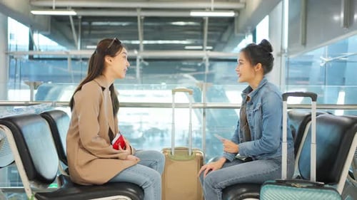 Passageira asiática esperando o embarque do avião no terminal do aeroporto.