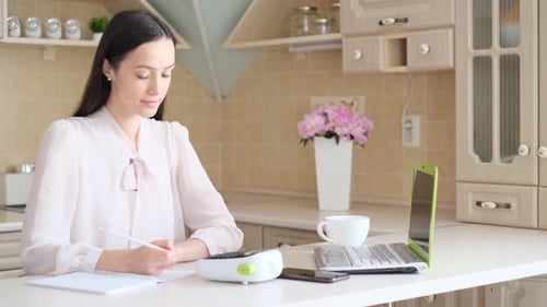 Woman Working from Home on Laptop in Kitchen