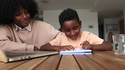 Woman Helping Child With Schoolwork at Home