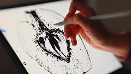 Woman hand painting on a graphic tablet with a white pen, close up