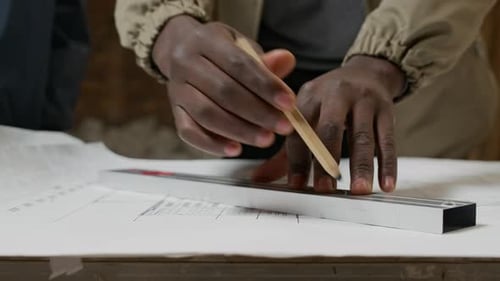 Hands of Architect Drawing on Draft of Blueprint in Unfinished Apartment