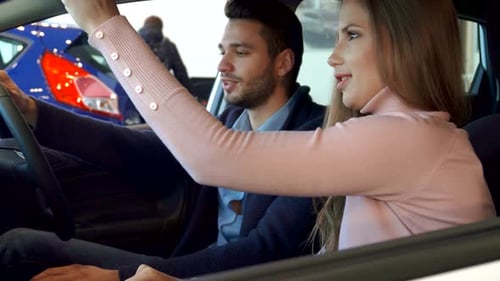 Couple Inspecting Interior of Car at Dealership