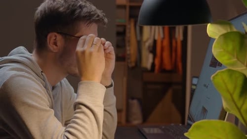 Man in glasses working on computer at home office desk