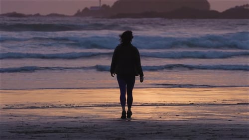Adventurous Woman Standing on the Sandy Beach on the West Coast of Pacific Ocean