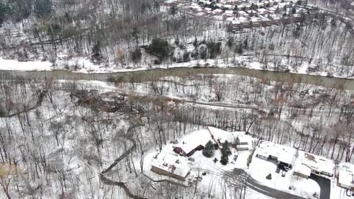 Flying over the edge of a town and river in the Winter