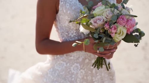 Bride Holding Flower Bouquet on Beach