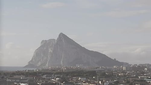 Eine Zeitrafferaufnahme aus Spanien, von Wolken, die bei Sonnenaufgang am Felsen von Gibraltar vorbeiziehen, als