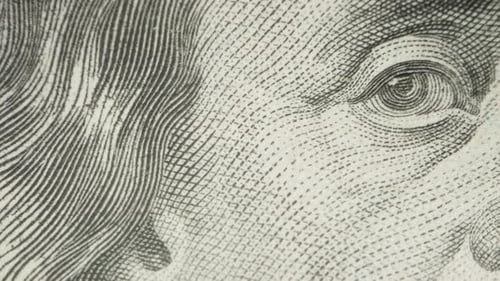 Portrait of Franklin on a hundred-dollar bill, eyes and nose. Dolly slider extreme close-up.
