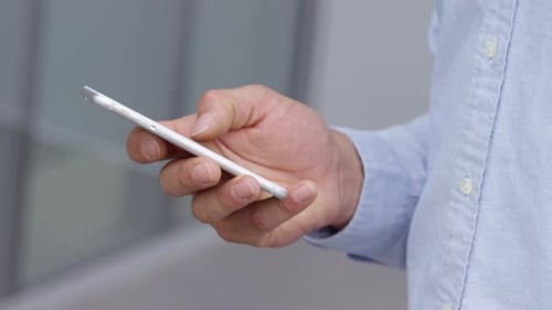 Hispanic businessman using his smartphone for communication at work