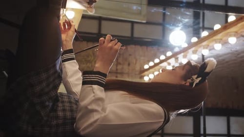 Young Woman Applying Makeup in Nighttime Setting