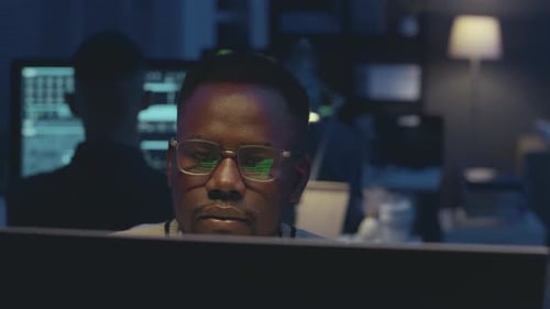 Cybersecurity Worker Working in Office at Night