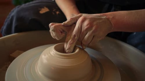 Close-Up of Hands of Artisan Forming Clay Vessel on Pottery Wheel