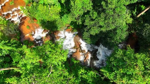 Aerial View of Waterfall Flowing Through Forest