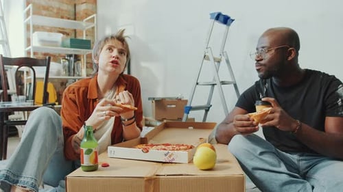 Friends Eating Pizza on Moving Boxes Indoors