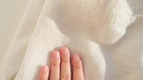 Close Up Hand Stroking Over the Surface Knitted Soft Wool Cloth or Warm Fluffy Sweater