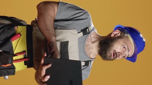 Vertical Video Portrait of Handyman Using Laptop to Find Construction Inspiration
