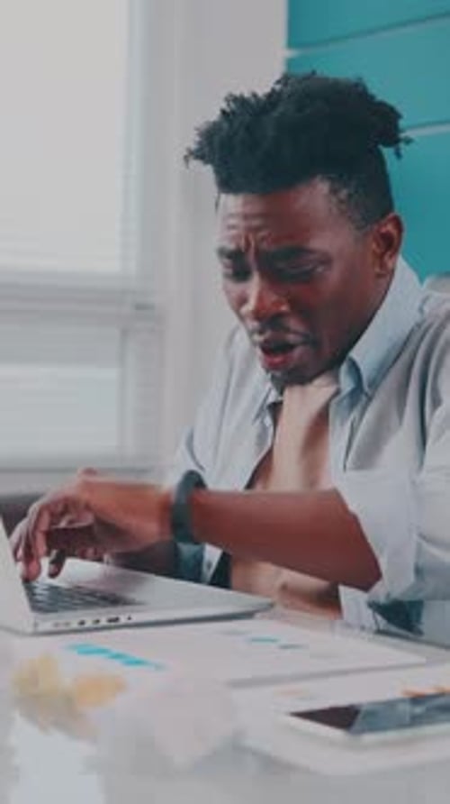 Young Man Working at Desk Feeling Sick