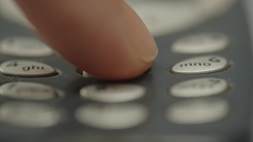 Finger pressing 555 on old cell phone