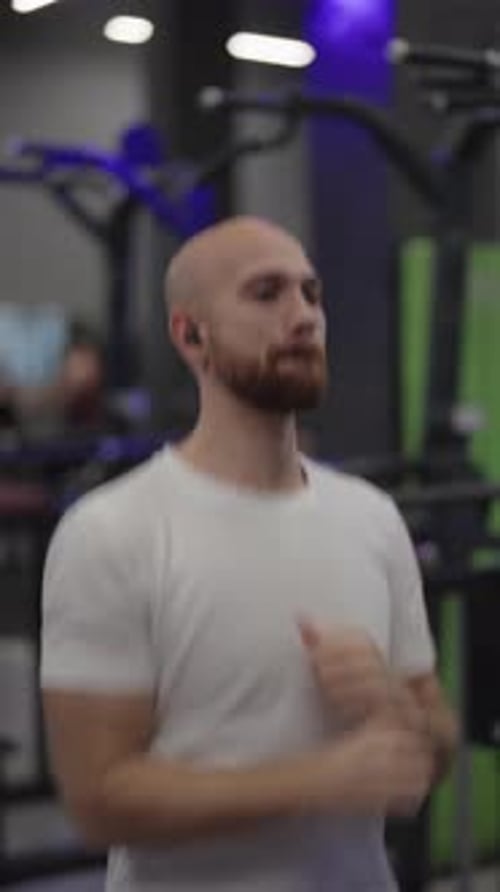 Bald Man Running on a Treadmill at the Gym