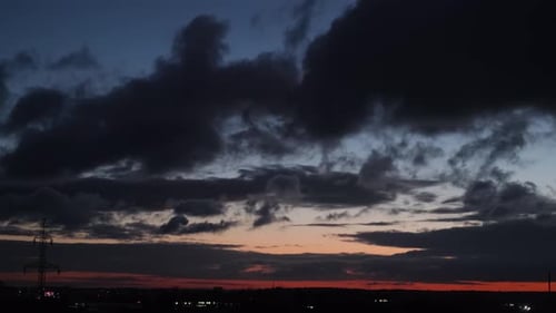 Energy Consumption of the City on the Background of the Sky with Dark Clouds at Sunset